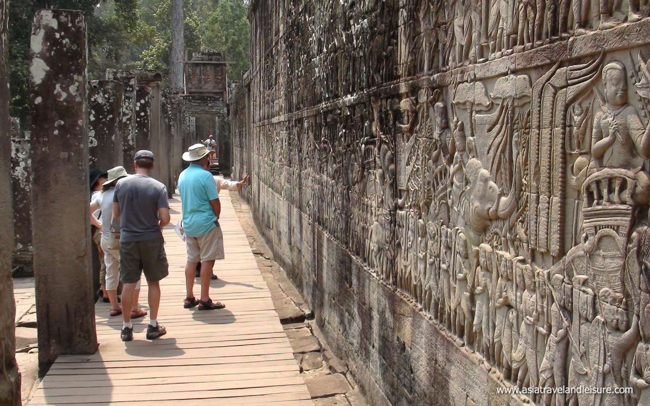 The tourist with a bas-relief statue of Khmer Culture in Angkor Wat, Cambodia