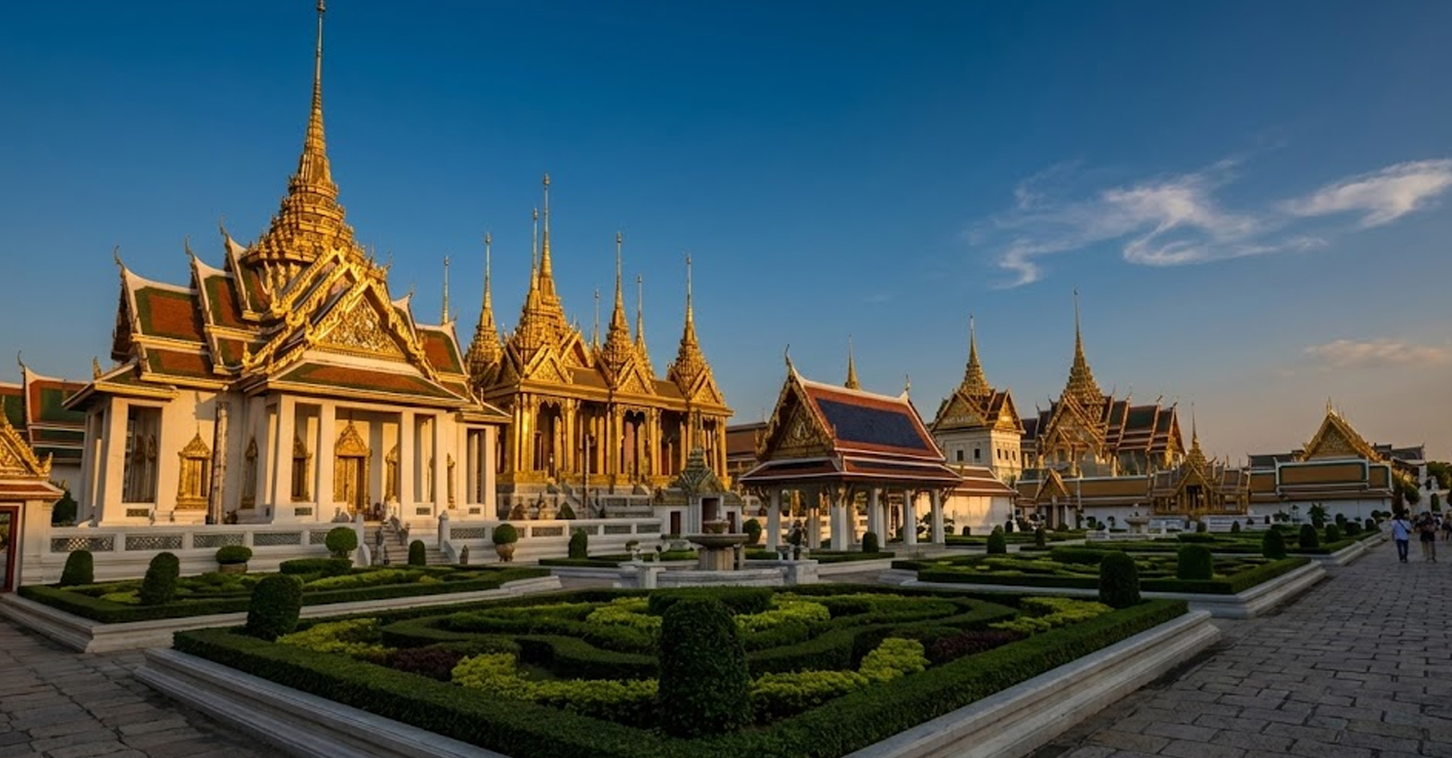 The Royal Palace is the glittering heart of Phnom Penh and a masterpiece of Khmer architecture. The golden spires of the Royal Palace in Phnom Penh glowing at sunset against a blue sky.