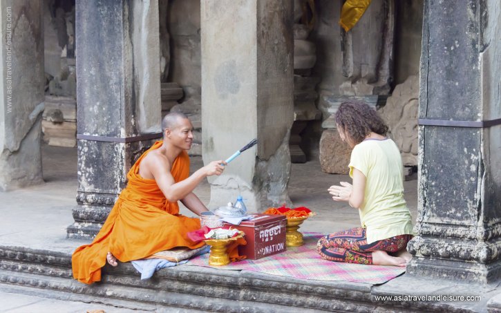 Buddhist monk give a wish to people in Angkor Wat